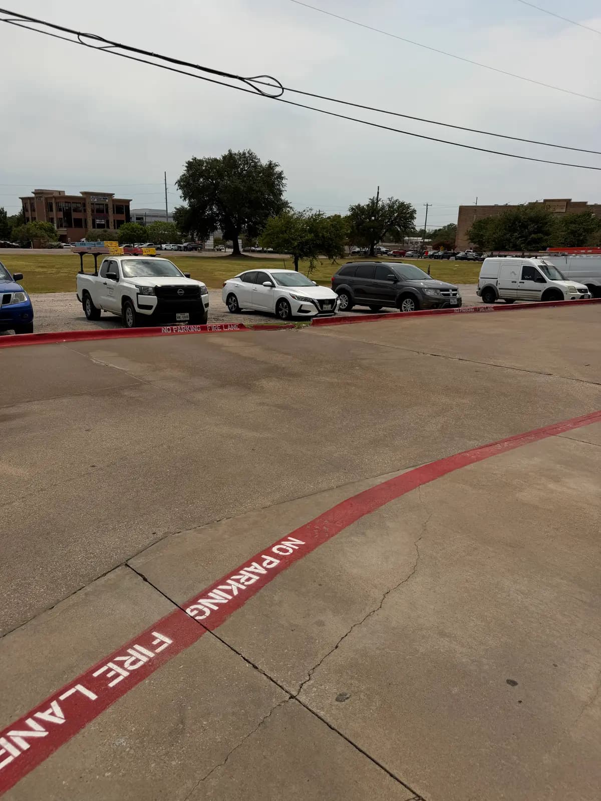 The same Mesquite, Texas dumpster pad after AquaFly Exterior Cleaning — grease and stains removed, bare concrete and fire lane striping restored